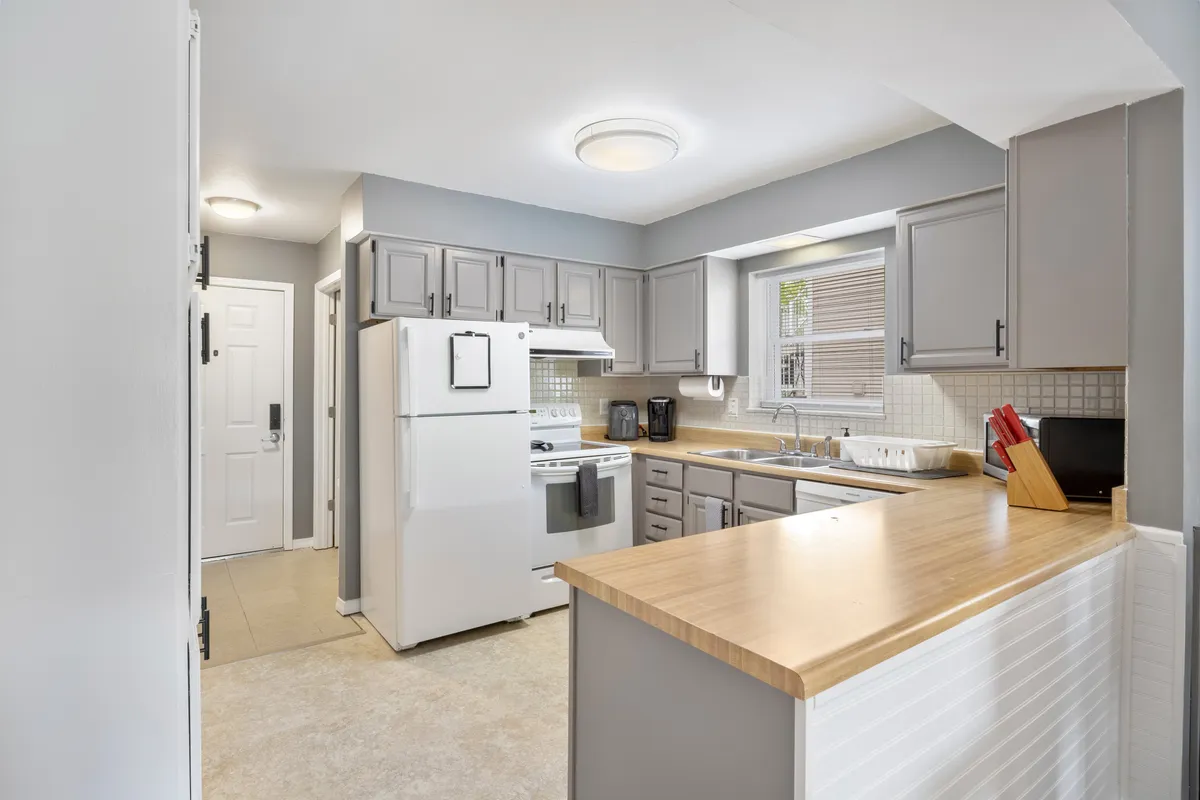 An inviting kitchen scene centered on a spacious island, well-equipped appliances, and ample counter space. The setting suggests plenty of room for group meal prep, shared cooking, or hosting casual gatherings, aligning with the idea of a well-stocked home ready for group enjoyment.
