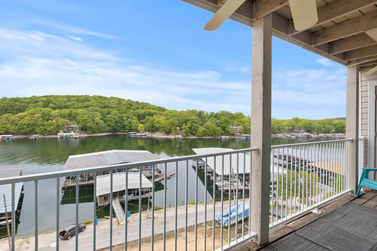 This tranquil view showcases calm lake waters bordered by lush vegetation and a few boathouses. The vantage point is likely from a private balcony or deck, perfectly positioned for sunrise paddles or stargazing at night. The water’s mirror-like surface and the enveloping greenery evoke a sense of peaceful immersion in nature.