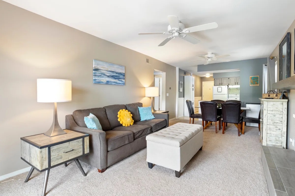 A warm, comfortable living area featuring a sofa, coffee table, and adjacent dining space. This arrangement invites guests to relax, socialize, or enjoy intimate celebrations together, reflecting the atmosphere of memorable group gatherings.